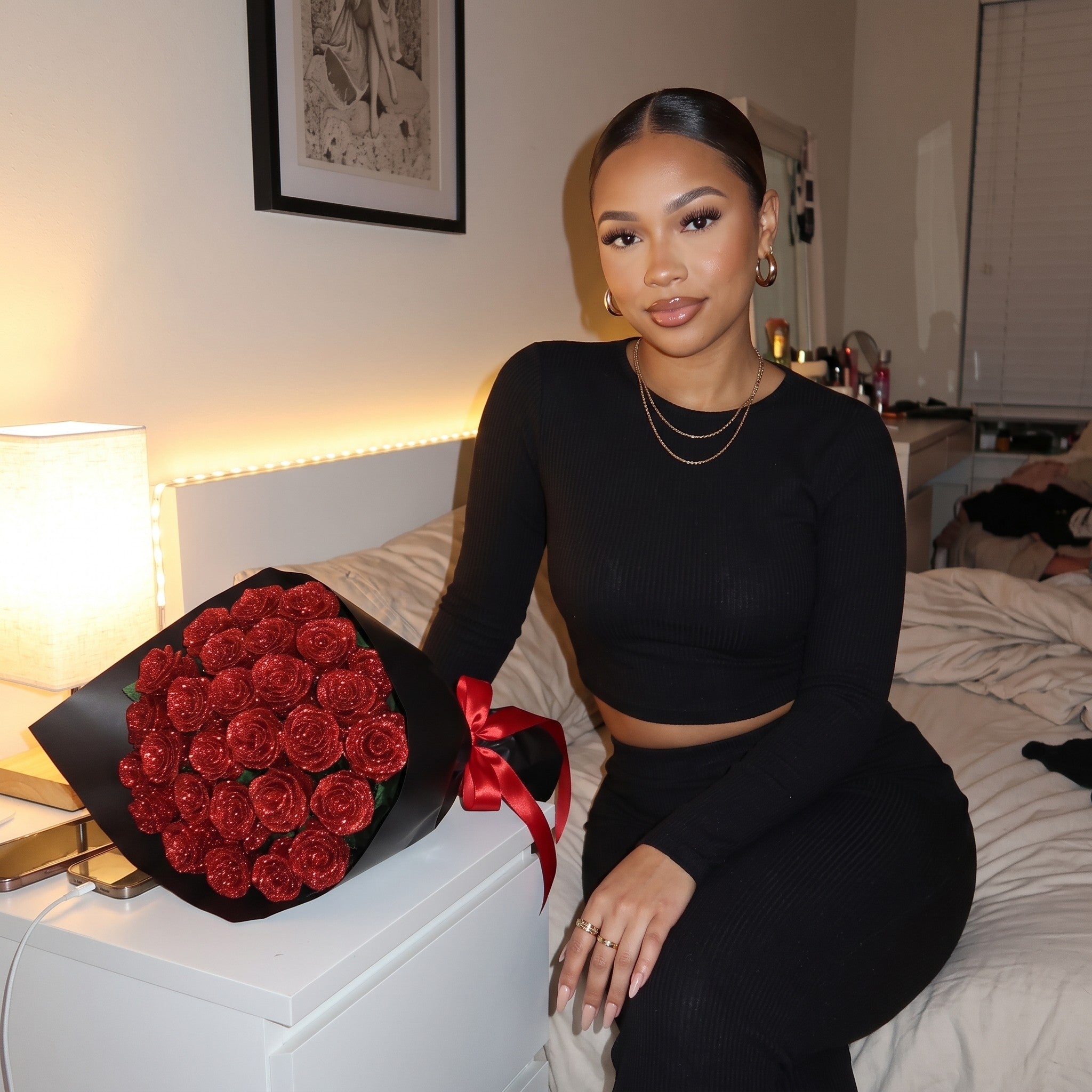 Woman on her bed with the glitter rose bouquet on her nightstand