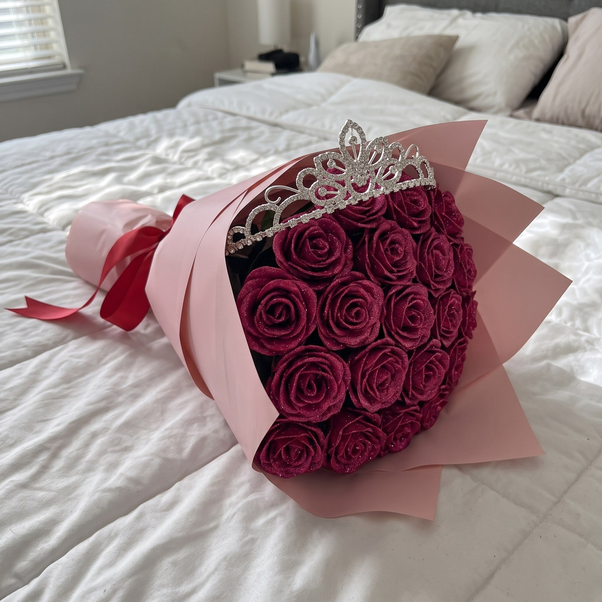 The crystal tiara sitting on top of a pink glitter rose bouquet