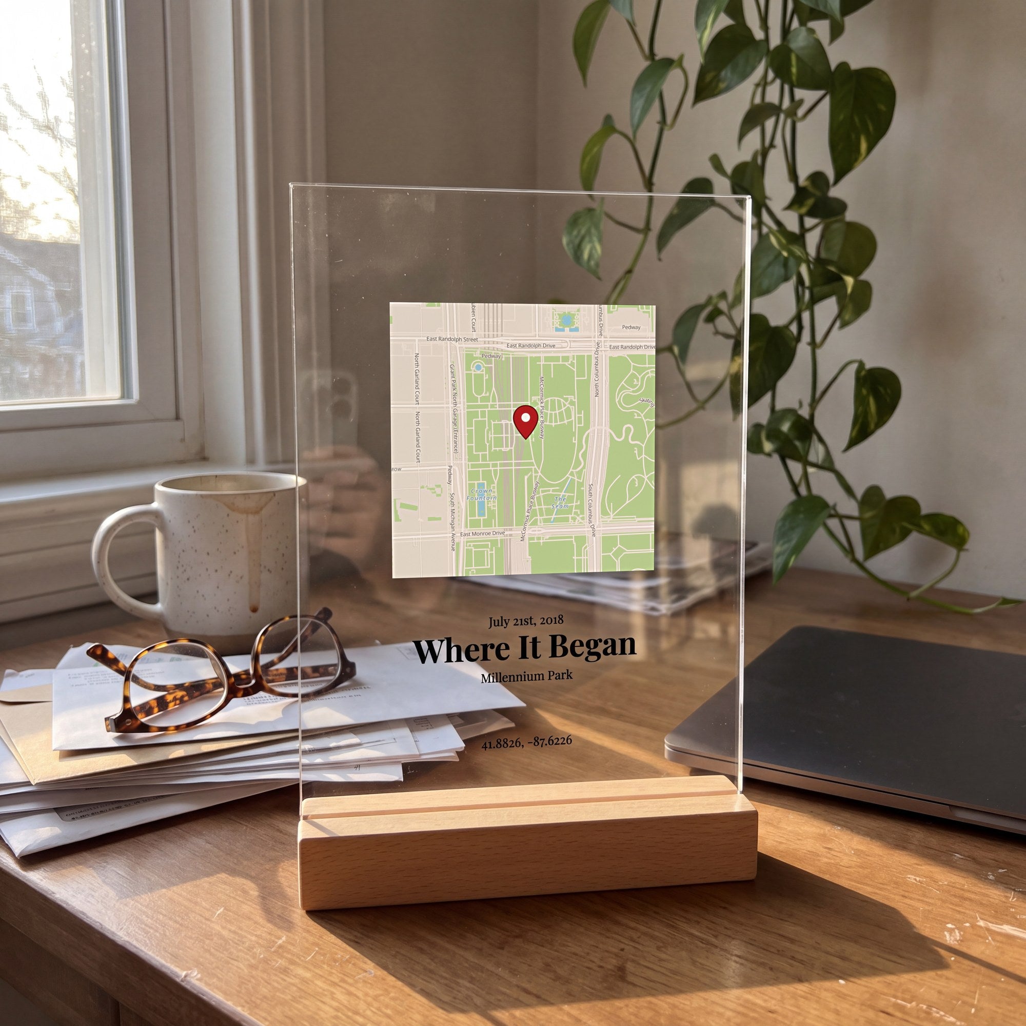 Clear map plaque of Millennium Park, Chicago, in a light wood stand on a sunny home desk